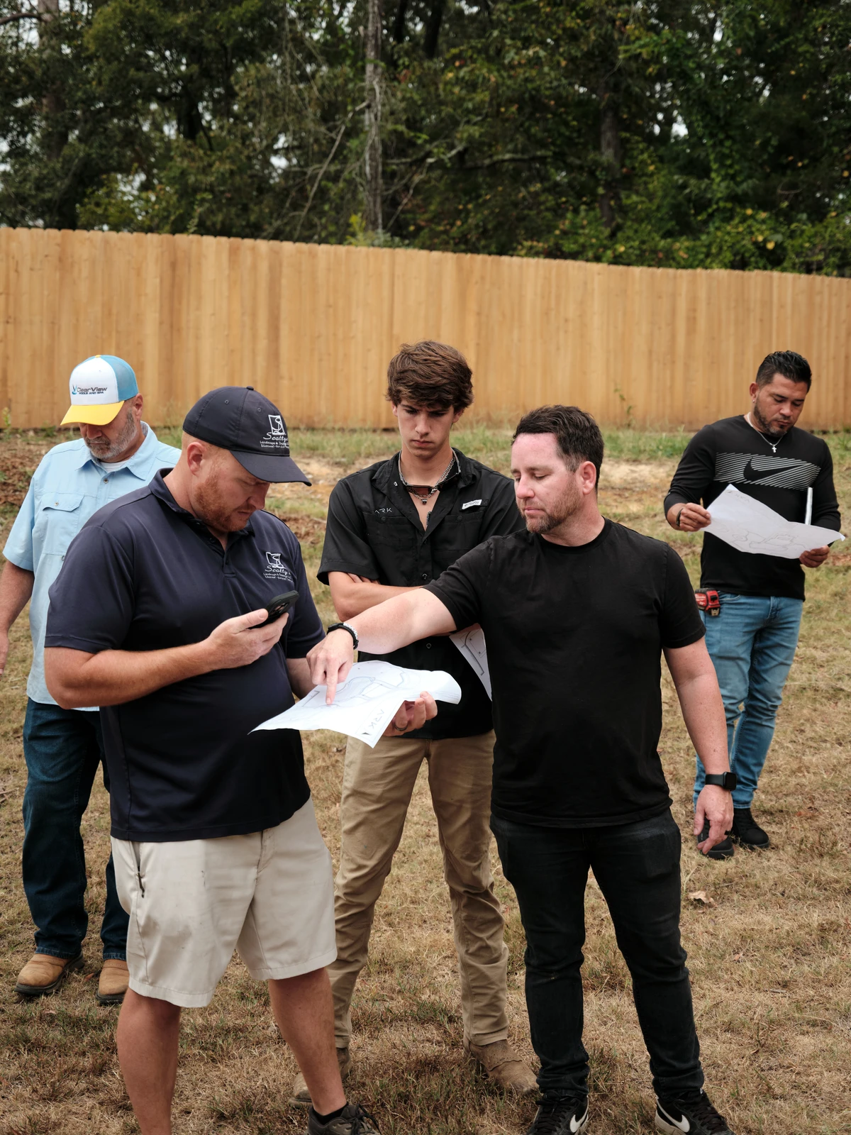Team reviewing construction plans outdoors